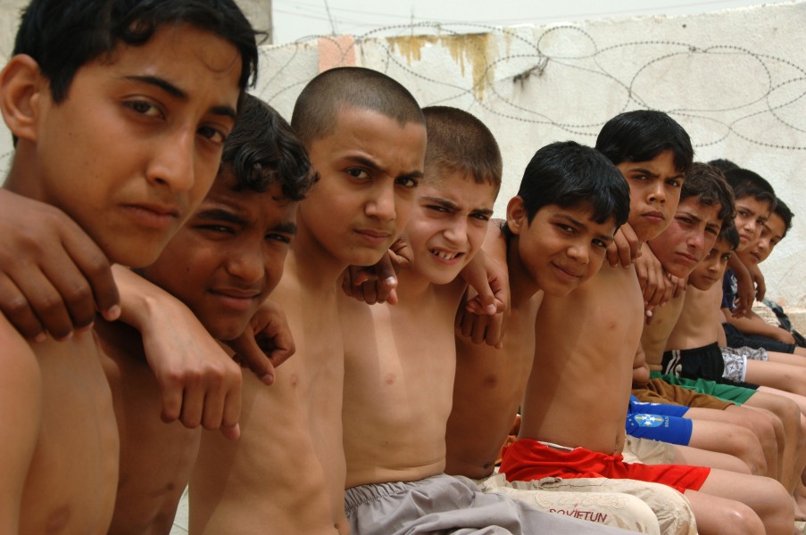 A group of Iraqi boys pose arm in arm for the camera waiting to be the first ones to dive into the pool, at the Jadida Public Swimming Pool, located in Eastern Baghdad, Iraq, June 7, 2008 080607-A-YE931-102