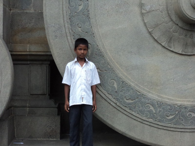 A Kid standing in front of the Wheel