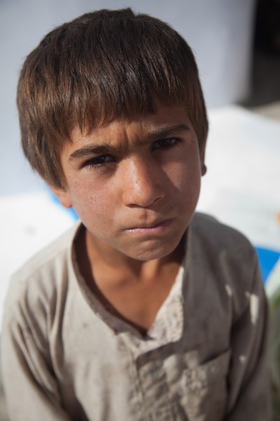 A young Afghan boy looks at the camera at the Women's Center at Forward Operating Base Pasab in Kandahar province, Afghanistan, Oct. 19, 2011 111019-A-VB845-023