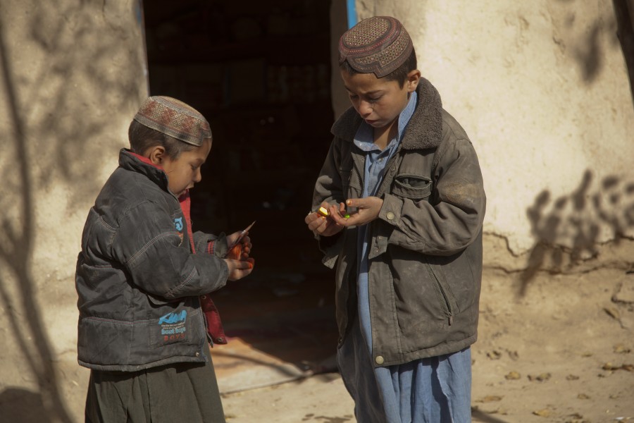 Afghan boys eat candy that U.S. Marines with India Company, 3rd Battalion, 7th Marines, Regimental Combat Team 8, gave them while on a security patrol in Sangin, Afghanistan, Dec. 7, 2011 111207-M-VK134-011