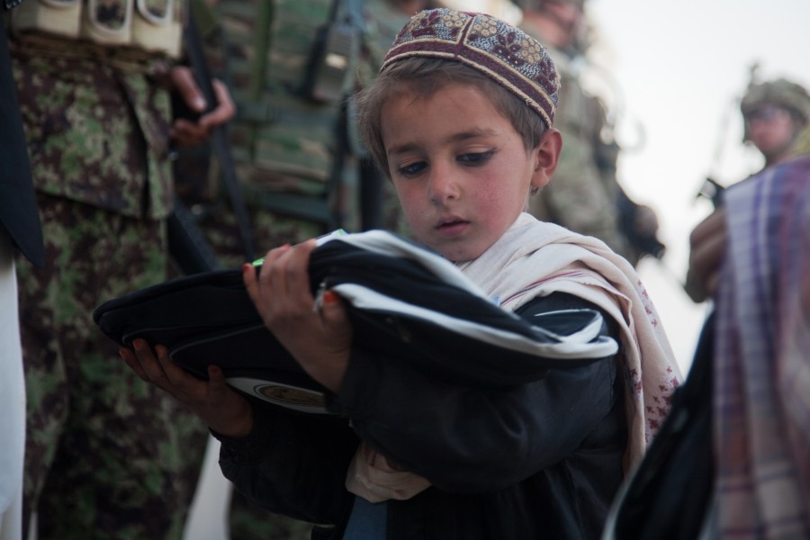An Afghan boy looks at his new backpack in Ananzai village, Kandahar province, Afghanistan, Dec. 26, 2011 111226-A-VB845-153