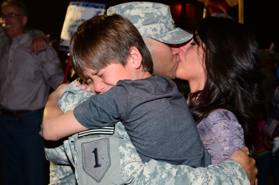 Army Sgt. Hector Jaime Sanchez, a communications Non-commissioned officer in charge, with Delta Battery, 4th Battalion, 5th Air Missile Defense Battalion, 69th Air Defense Artillery Brigade, embraces his 121103-A-DO086-276