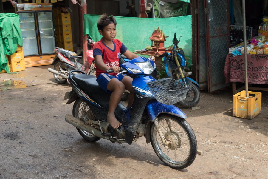 Boy riding a motorcycle in Laos