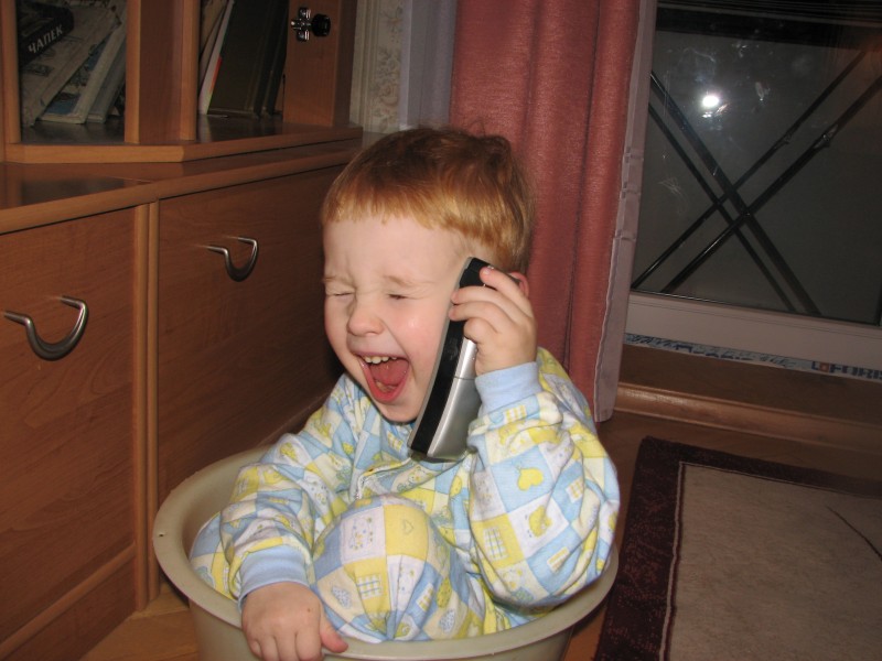 A small funny boy talking over the phone