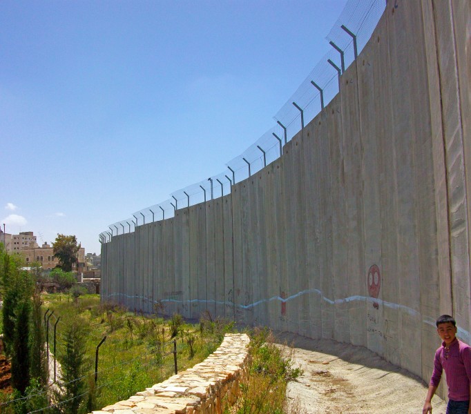 Palestinian boy with Israeli separation barrier at Bethlehem