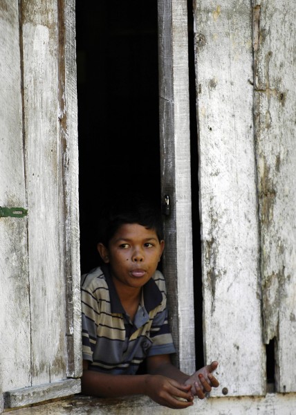 US Navy 050116-N-4166B-023 An Indonesian boy in Gunung Setui on the island of Sumatra, Indonesia, looks out the window of his home