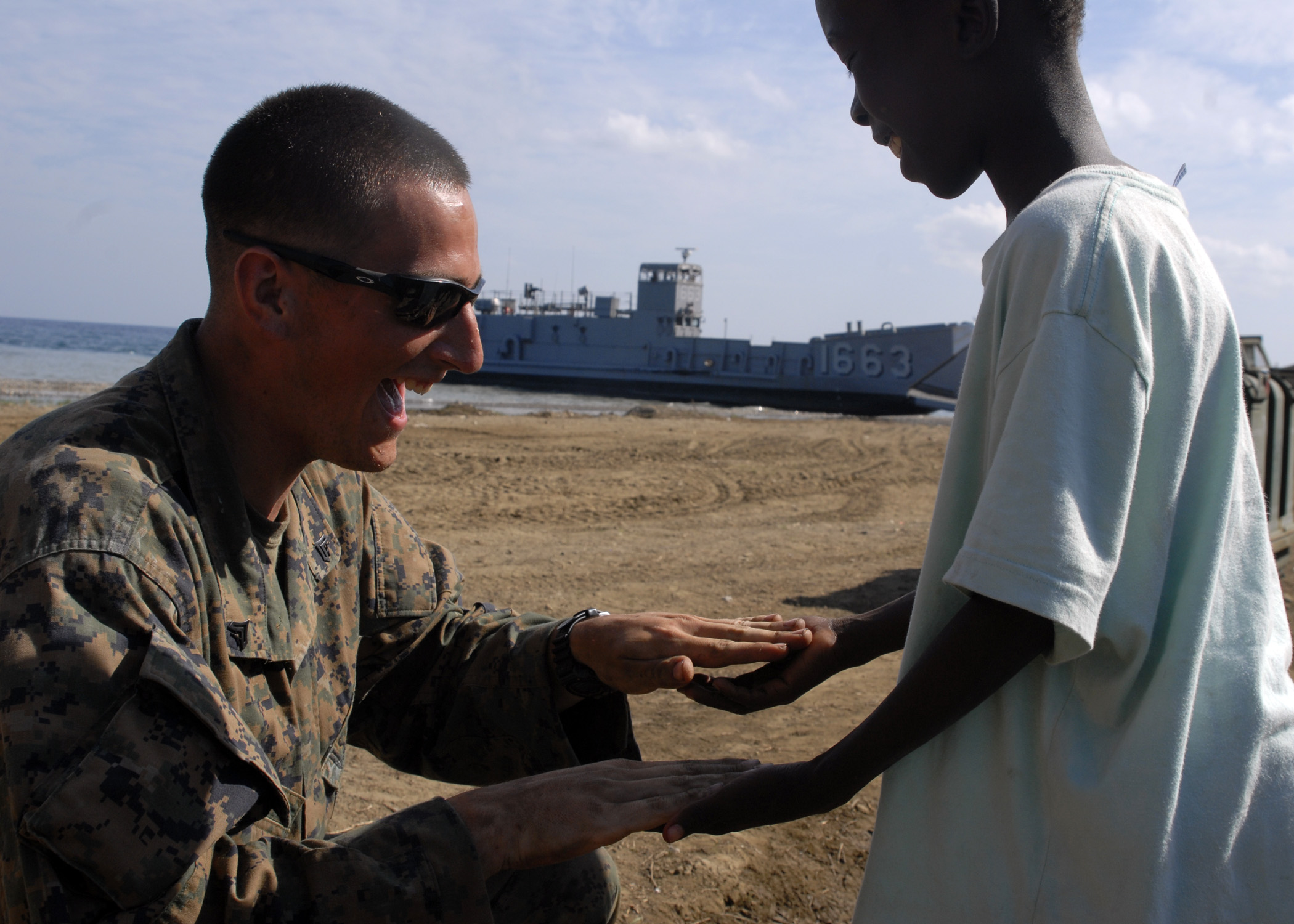 US Navy 100213-N-2000D-108 A Marine plays with a Haitian child
