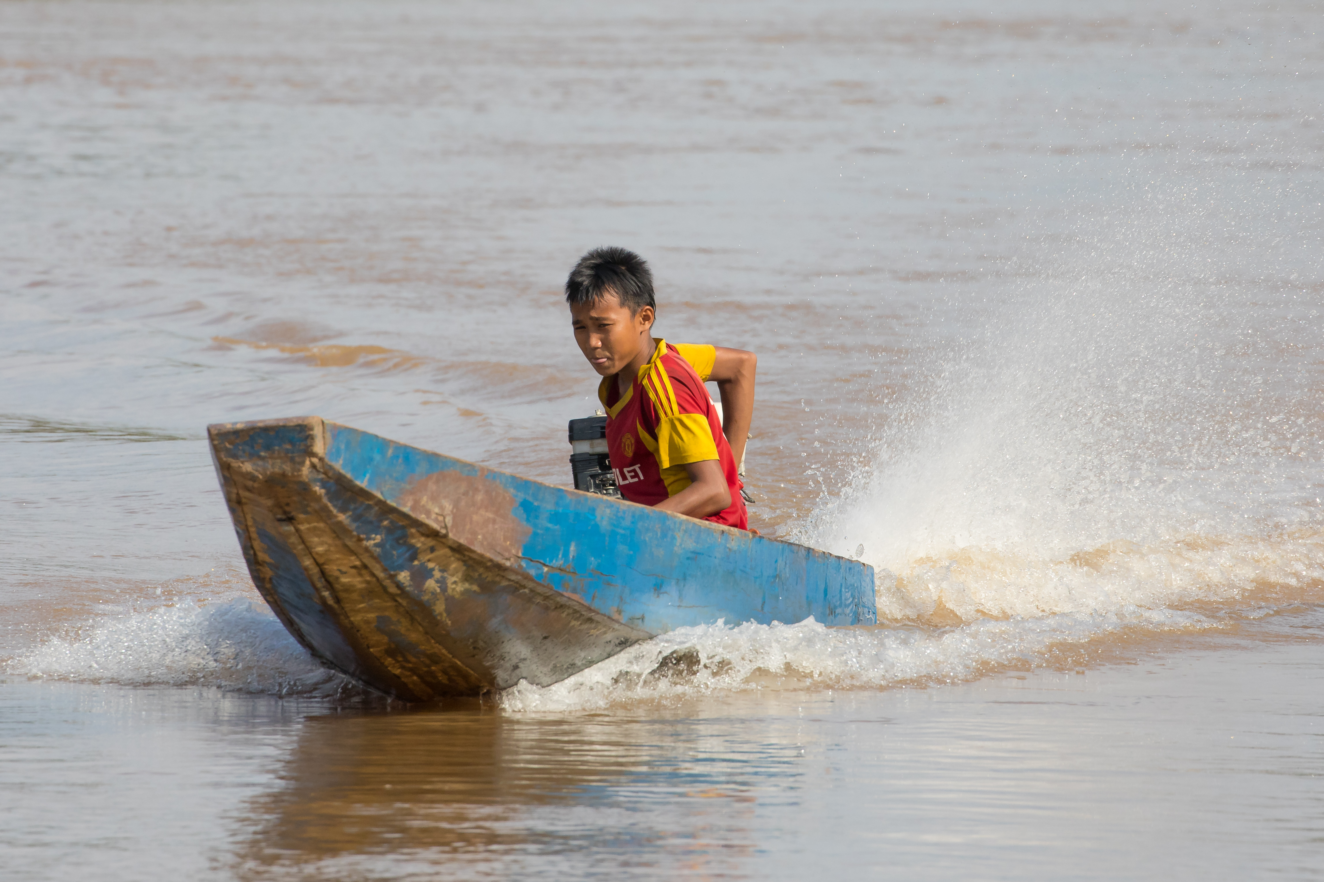 Young boy driving a motorized pirogue