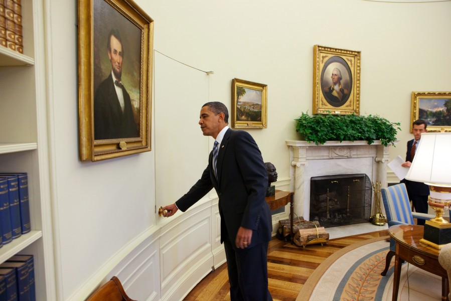 President Barack Obama opens the door of the Oval Office
