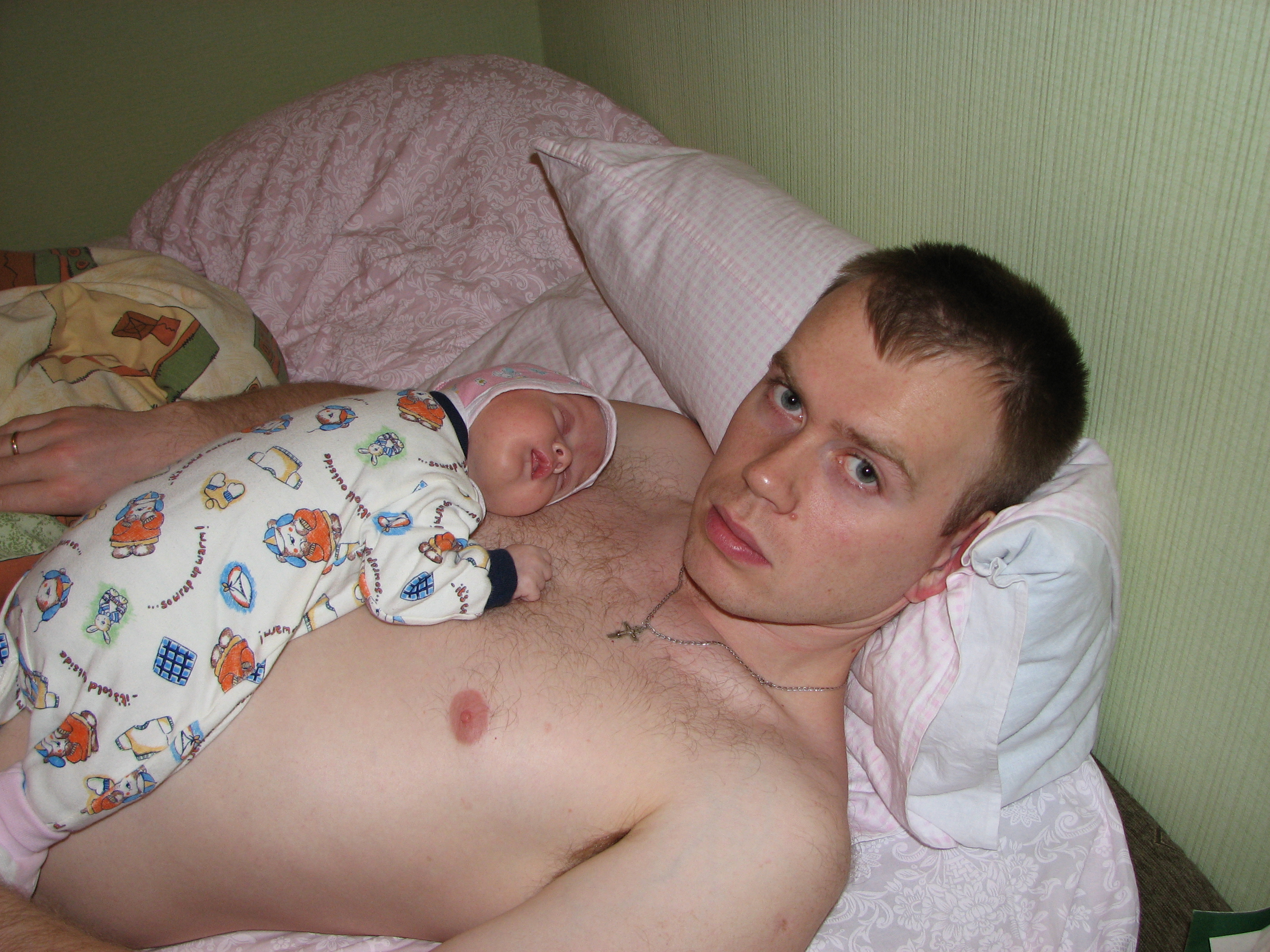 Young father with his baby kid on his chest.