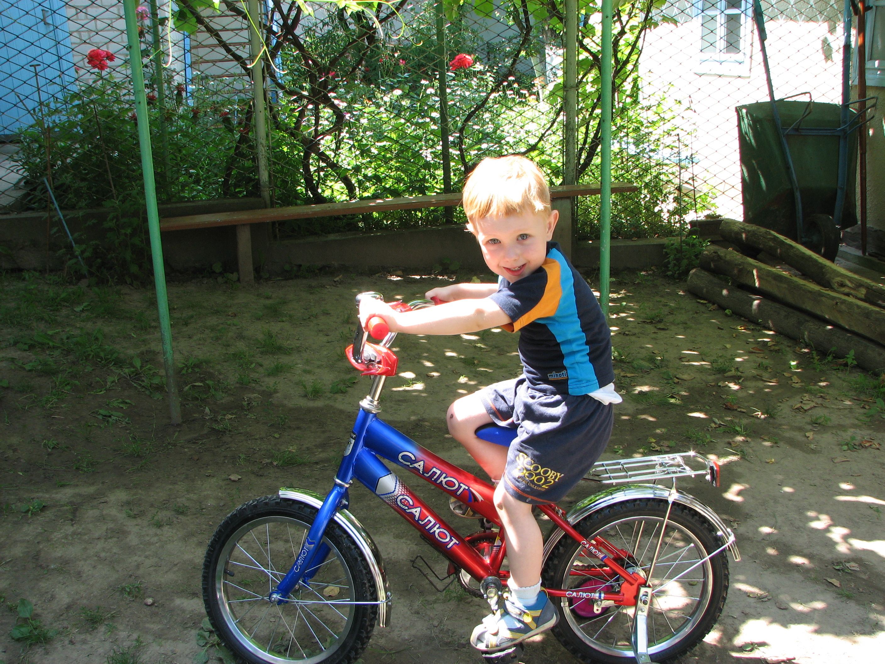 A small boy learning to ride one of his first bicycles