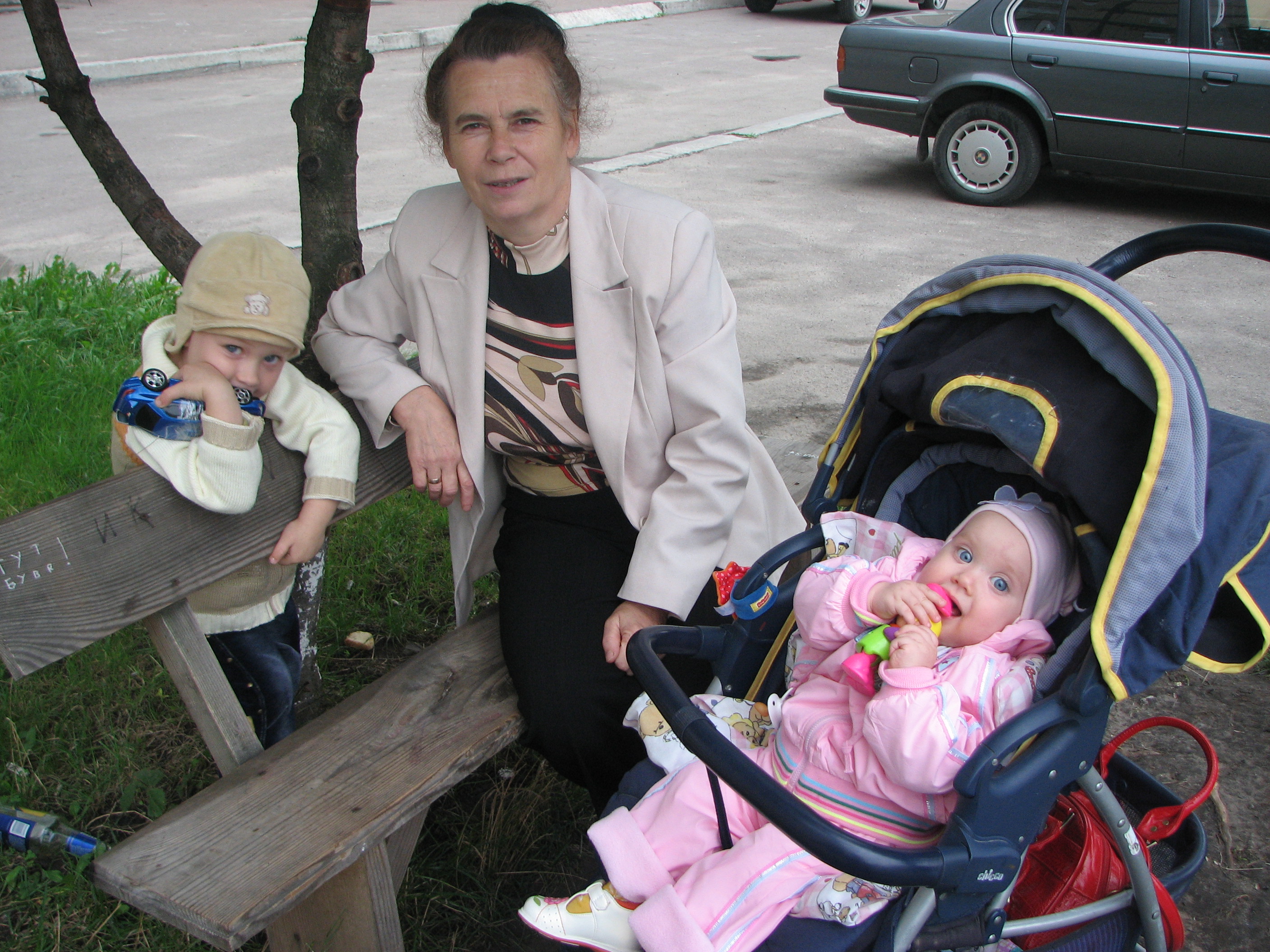 Grandmother with her baby granddaughter and grandson, family.