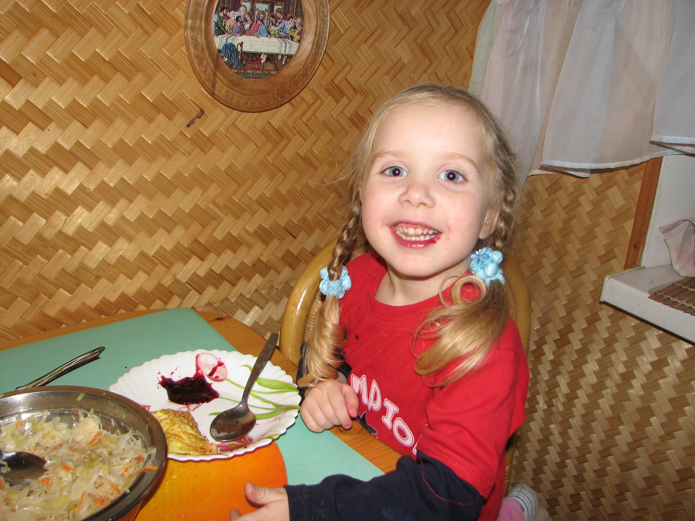 A small girl eating at a table