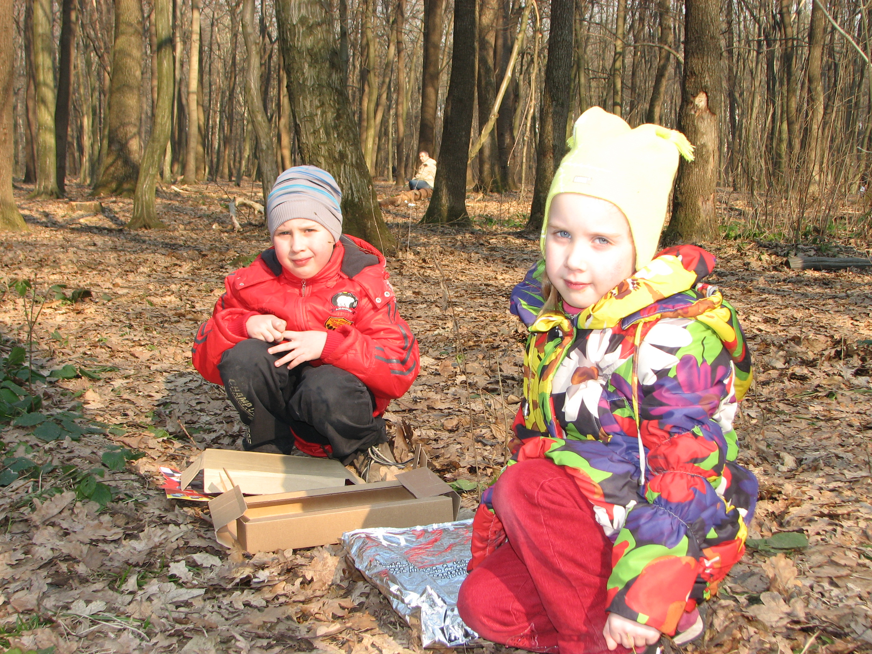 A small boy and a small girl in a forest