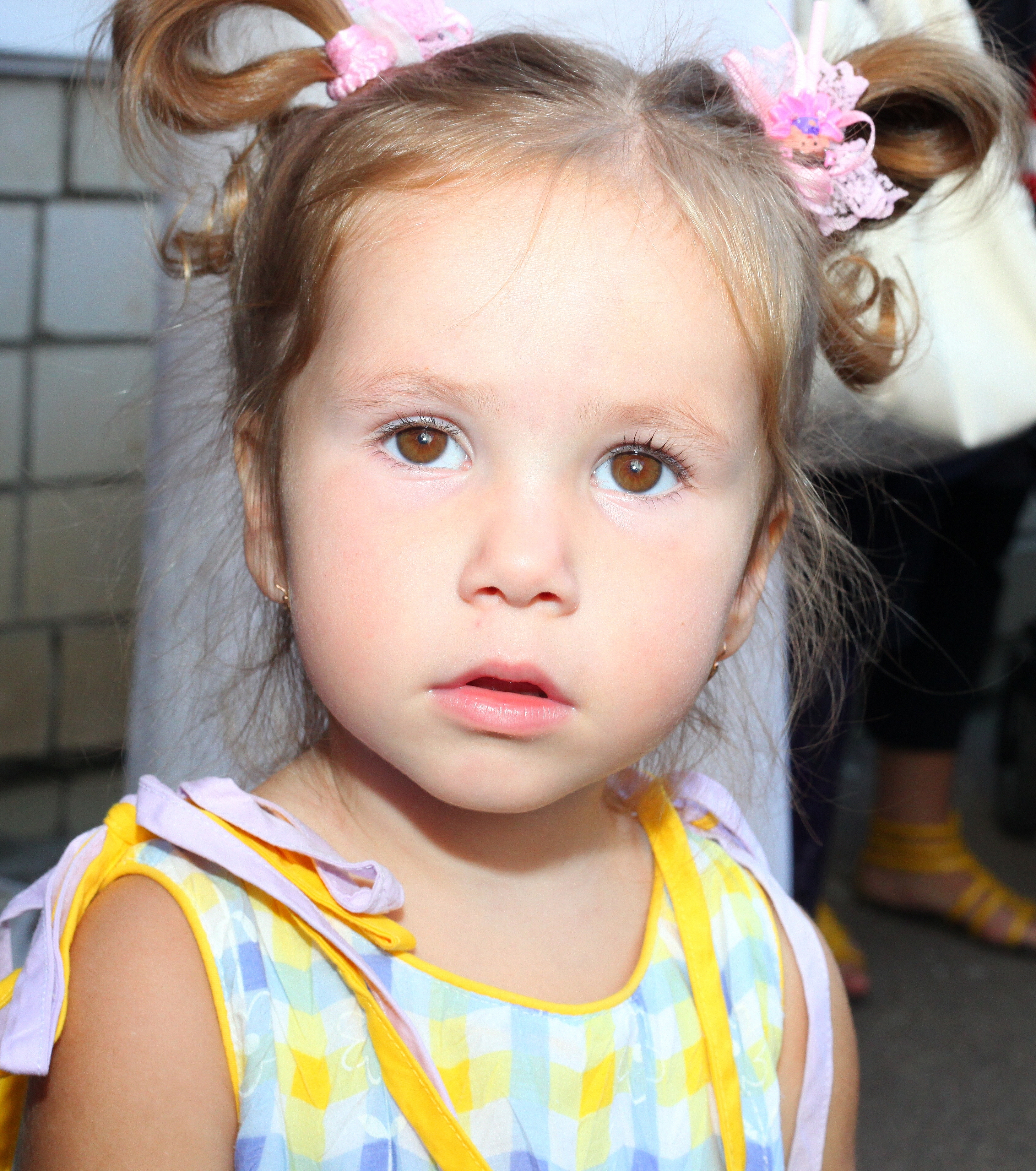 a cute baby girl with brown eyes and plaits