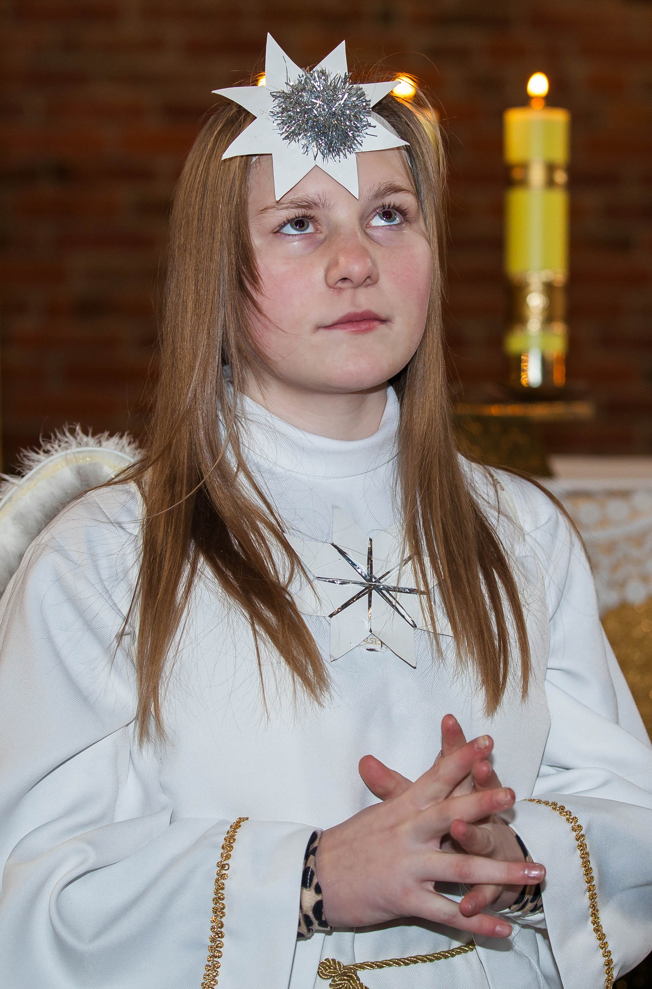 a young Catholic blond girl performing in a play in December 2013, image 1/2