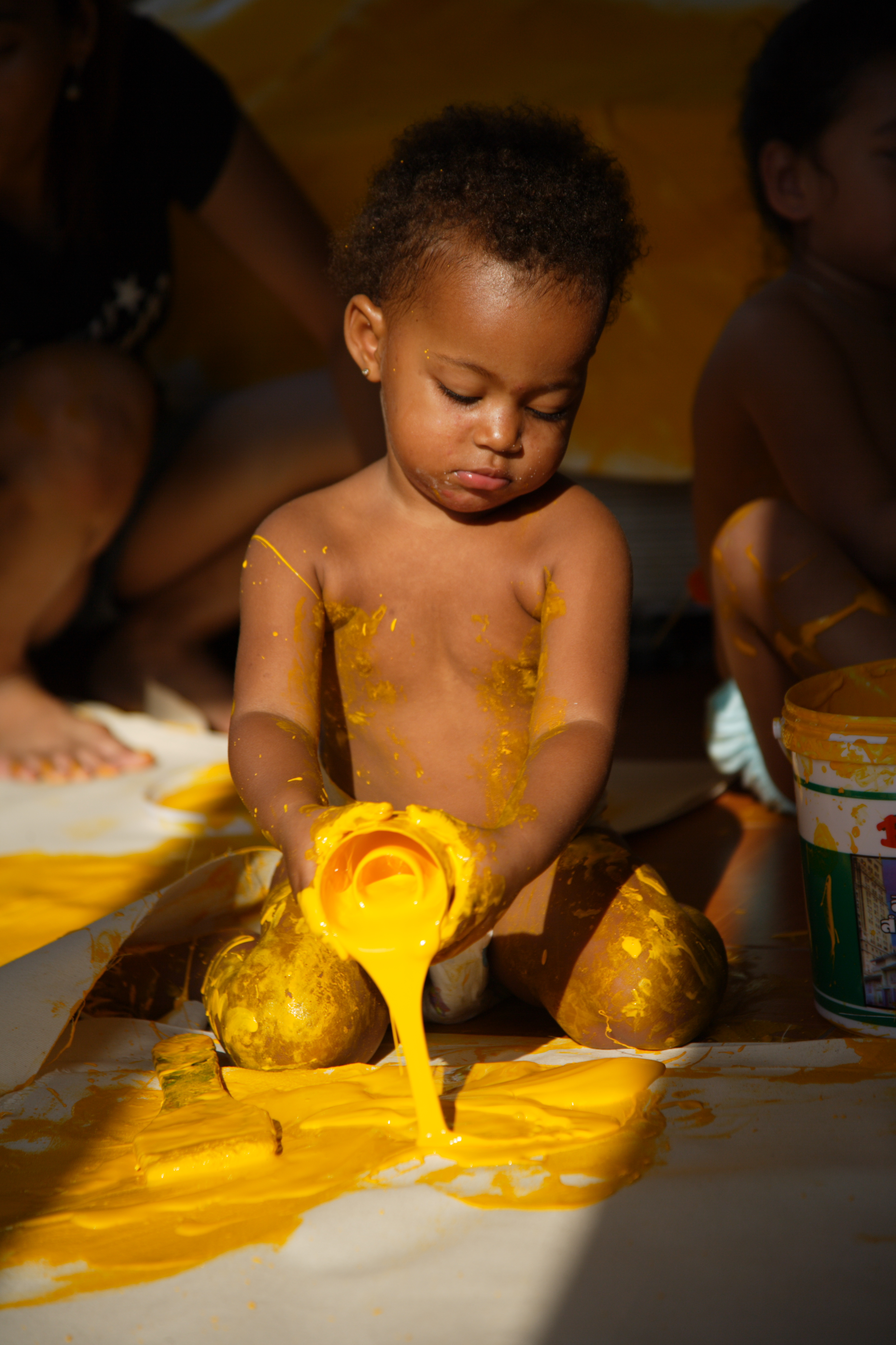 Baby playing with yellow paint. Work by Dutch artist Peter Klashorst entitled 