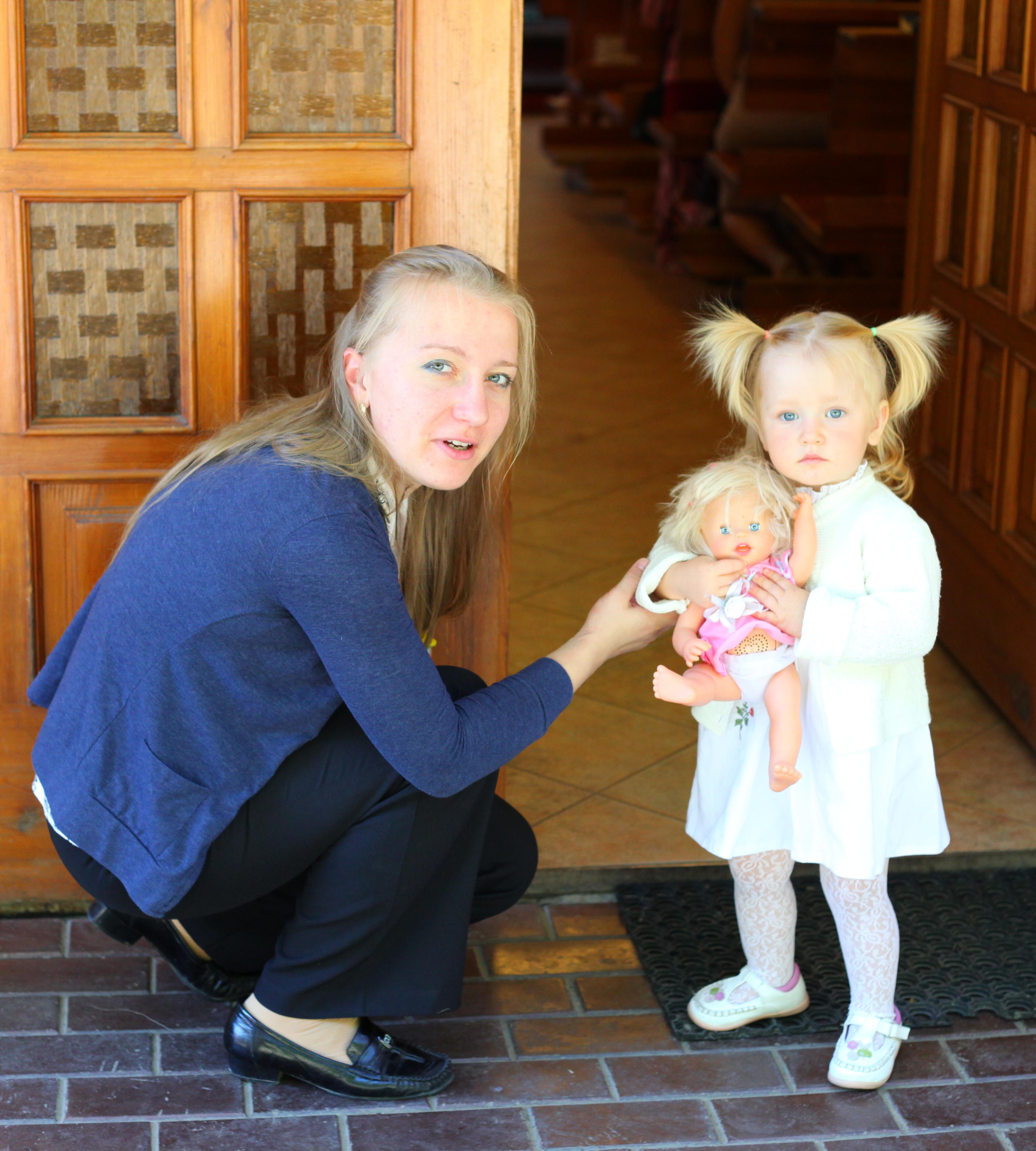 A young blond Catholic mother with her baby daughter