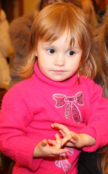 a cute baby girl with dark eyes in a Catholic Church, photo 2