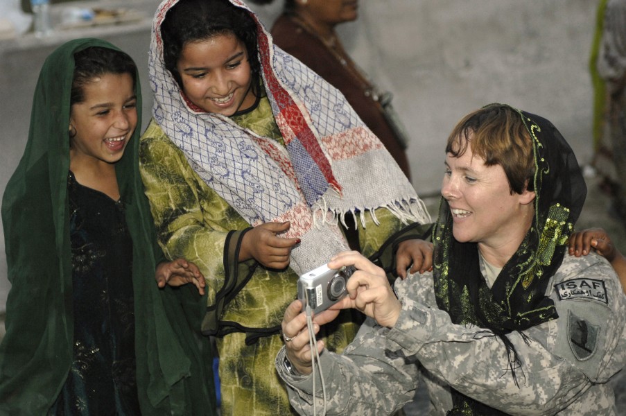 Defense.gov News Photo 101009-F-9227G-171 - U.S. Army Capt. Marie Orlando shows Afghan girls photos during their weekly Girl Scout meeting at Forward Operating Base Finley-Shields
