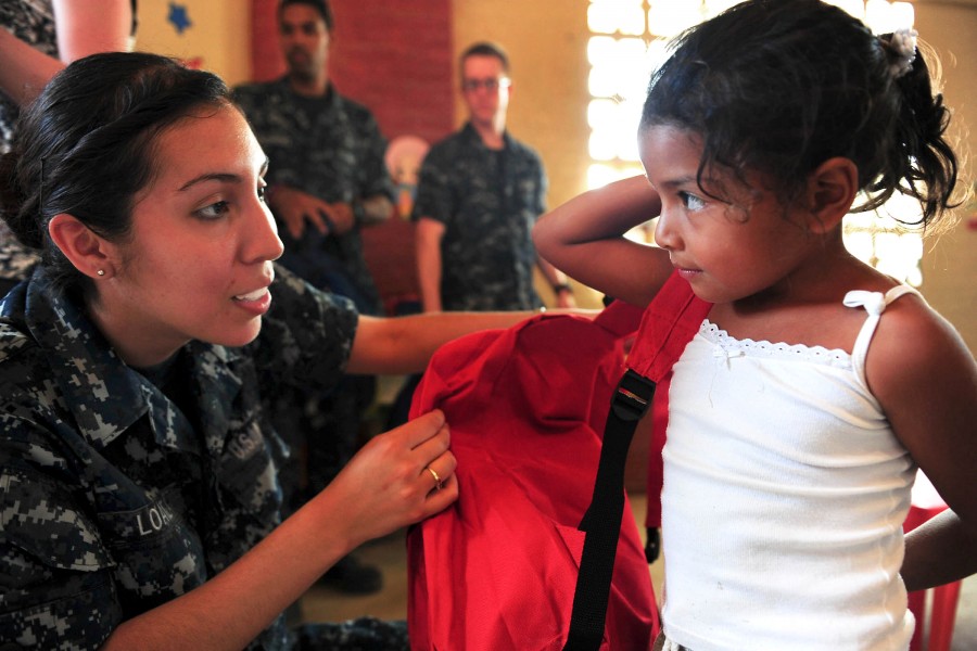 Defense.gov News Photo 110520-N-QD416-443 - U.S. Navy Seaman Arianna Loaiza helps a student put on a donated backpack during a Continuing Promise 2011 community service event in Santa Rosa