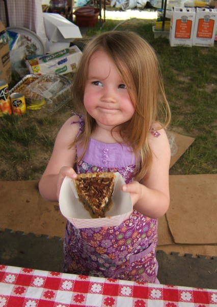 Little girl serving a pecan pie.