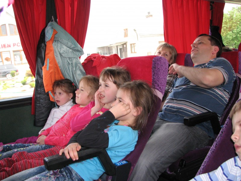 People on a pilgrimage, watching video in a bus