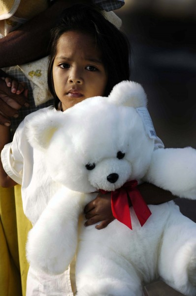 US Navy 050109-N-4166B-021 A young Indonesian girl clasps her new teddy bear, given to her by Sailors assigned to USS Abraham Lincoln (CVN 72)