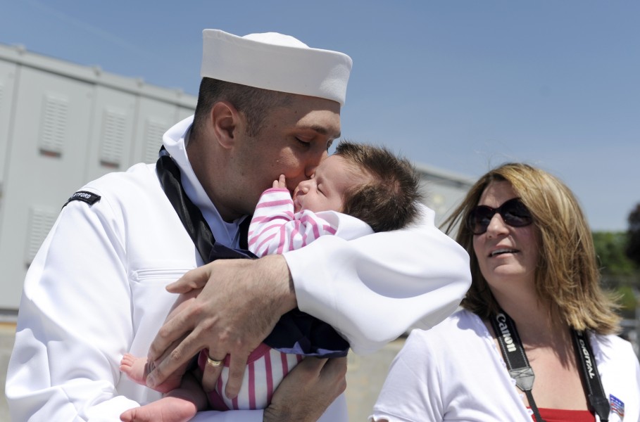 US Navy 090521-N-8467N-004 Hospital Corpsman 1st Class Chris Yaras holds his four-week old daughter for the first time as his wife looks on