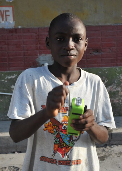 US Navy 100124-N-6214F-019 A Haitian child uses the hand crank on his multi-purpose self-powered radio
