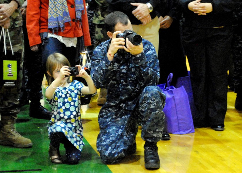 US Navy 101205-N-0687C-070 Mass Communication Specialist 2nd Class Jason Tross shows his daughter what he does as a Reserve Component Sailor during