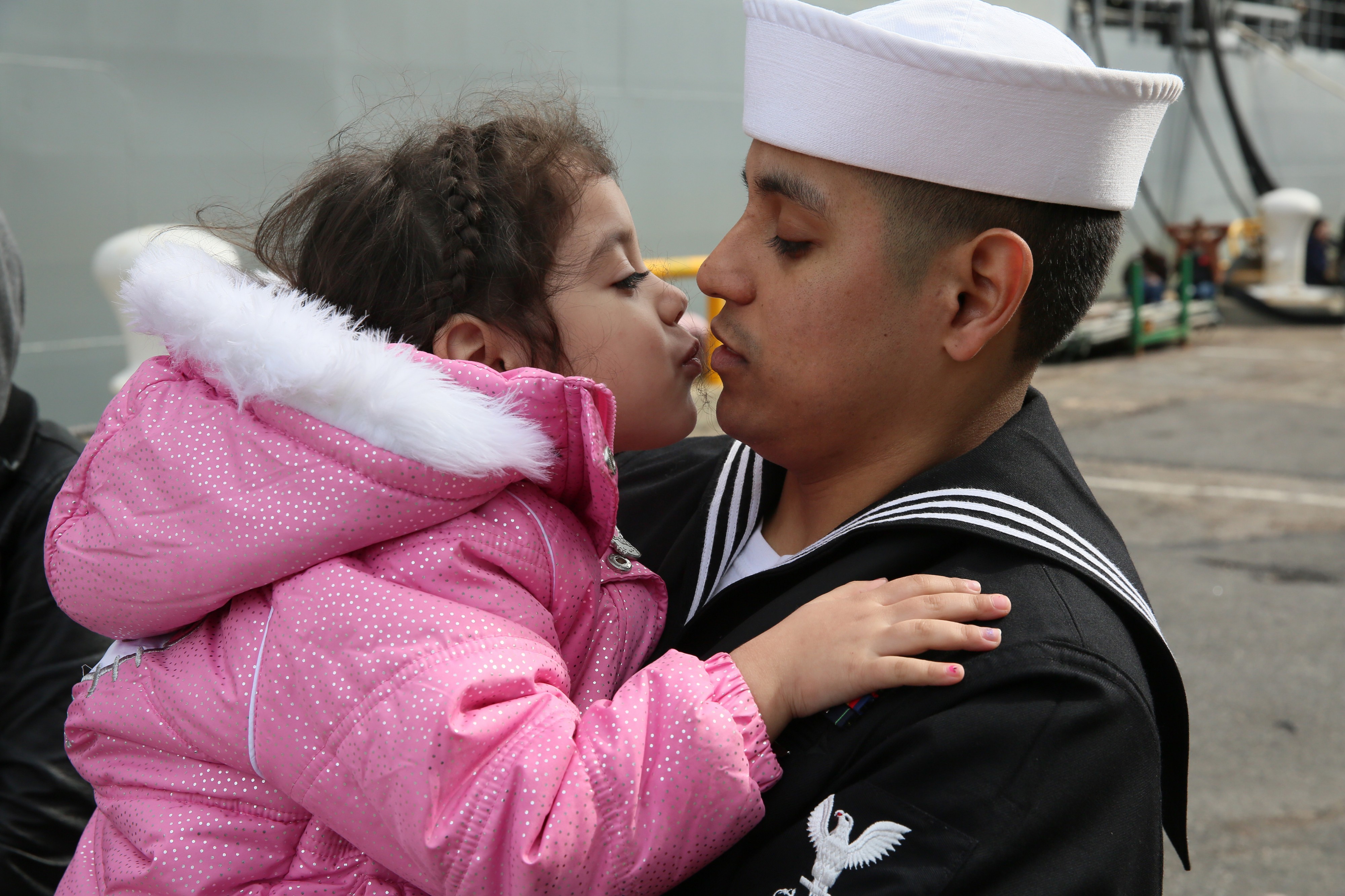 U.S. Navy Mass Communication Specialist 2nd Class Jonathan Vargas, right, assigned to the amphibious assault ship USS Kearsarge (LHD 3), says goodbye to his daughter prior to boarding the ship at Naval Station 130311-N-SB587-021