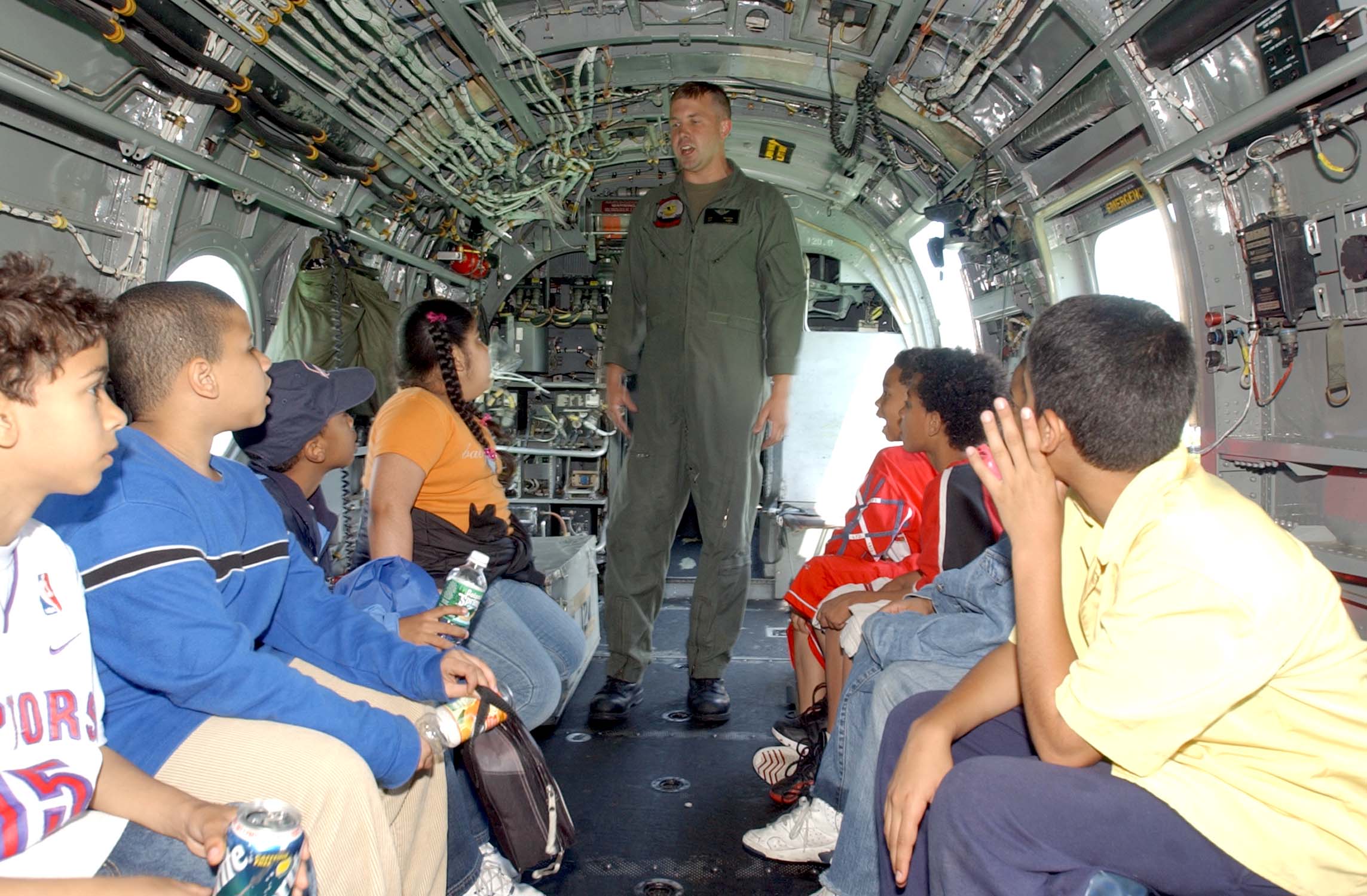 US Navy 040527-N-4936C-112 U.S. Marine Corps Sgt. George Watson, assigned to Marine Medium Helicopter Squadron Seven Seven Four (HMM-774), talks to children inside a CH-46E Sea Knight