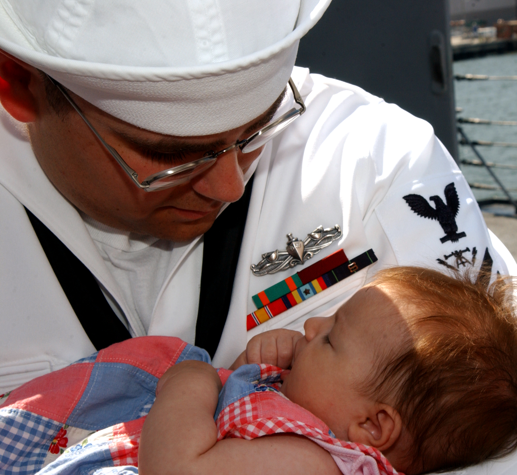 US Navy 040527-N-7631T-037 Fire Controlman 2nd Class Mathew Bergoschije embraces his new daughter Hannah during homecoming celebrations