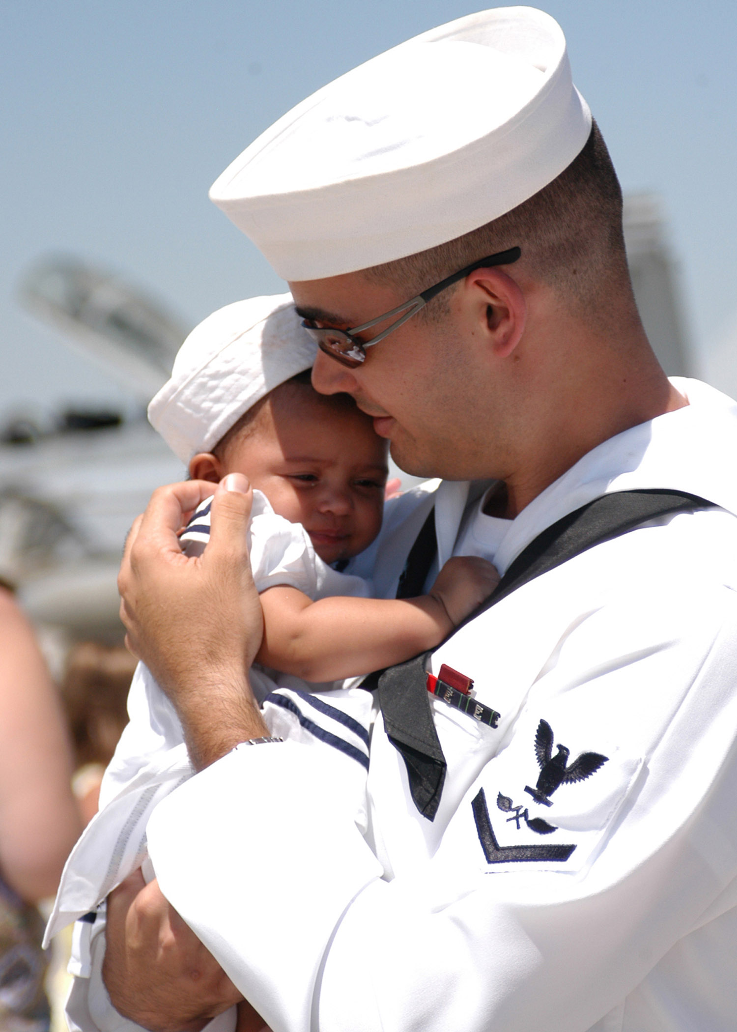 US Navy 050731-N-6367N-027 A Sailor hold his child for the first time after returning from a six-month deployment