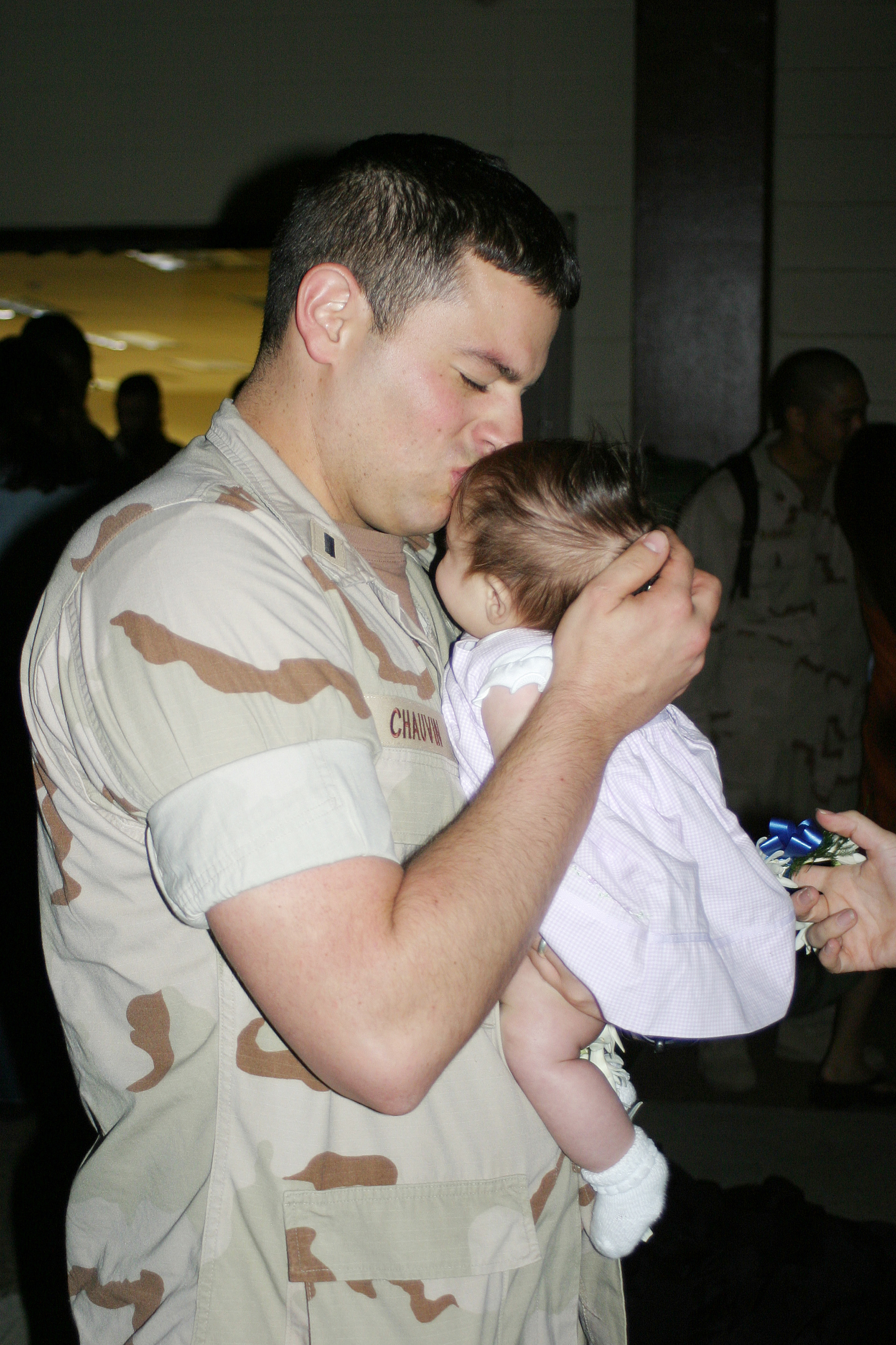 US Navy 060530-N-3207B-023 Lt.J.G. Andrew Chauvin, assigned to the Golden Swordsmen of Patrol Squadron Four Seven (VP-47), kisses his newborn baby for the first time