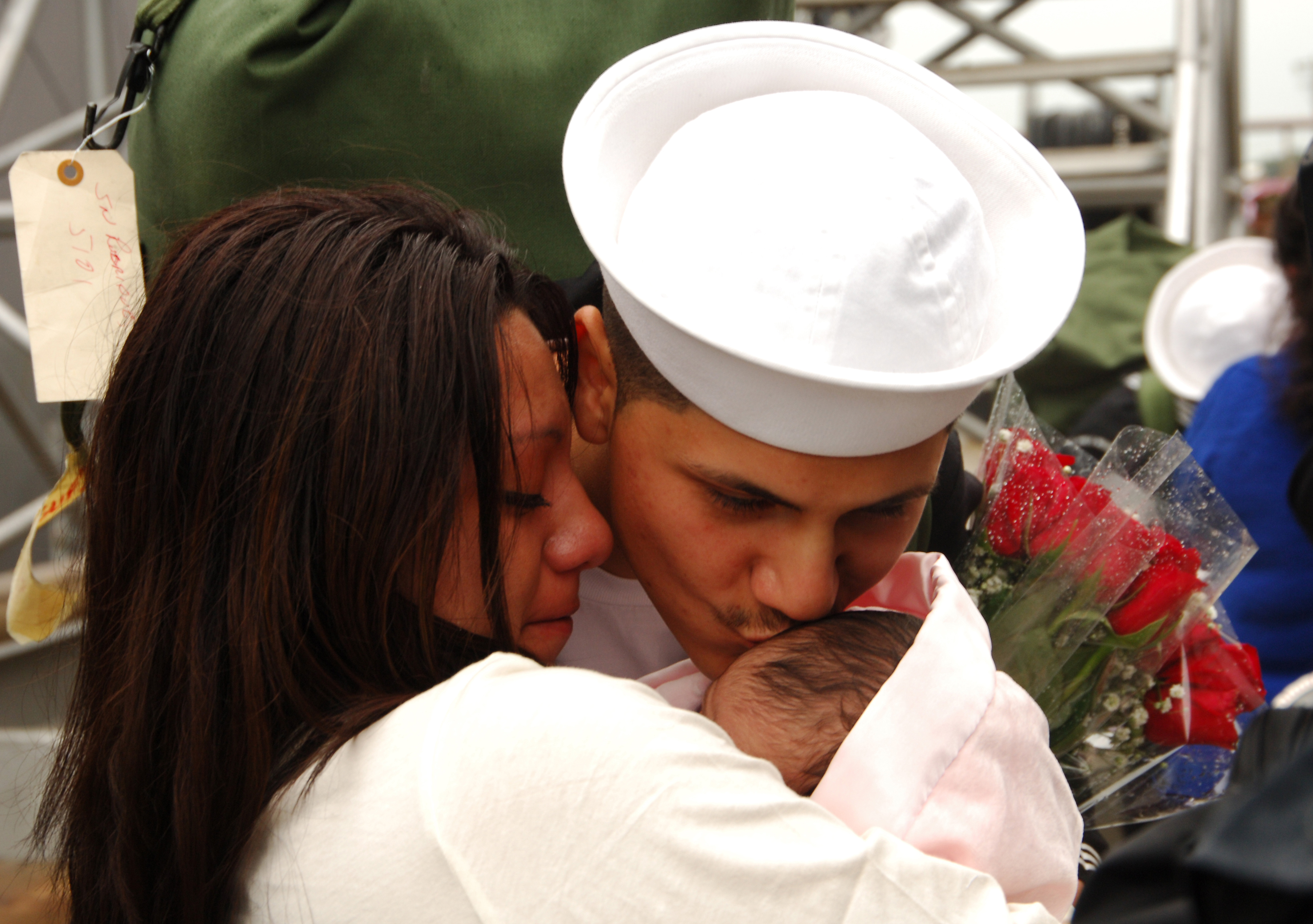 US Navy 061017-N-1831S-158 A Sailor aboard the guided-missile destroyer USS James E. Williams (DDG 95) kisses his child for the first time after returning from deployment