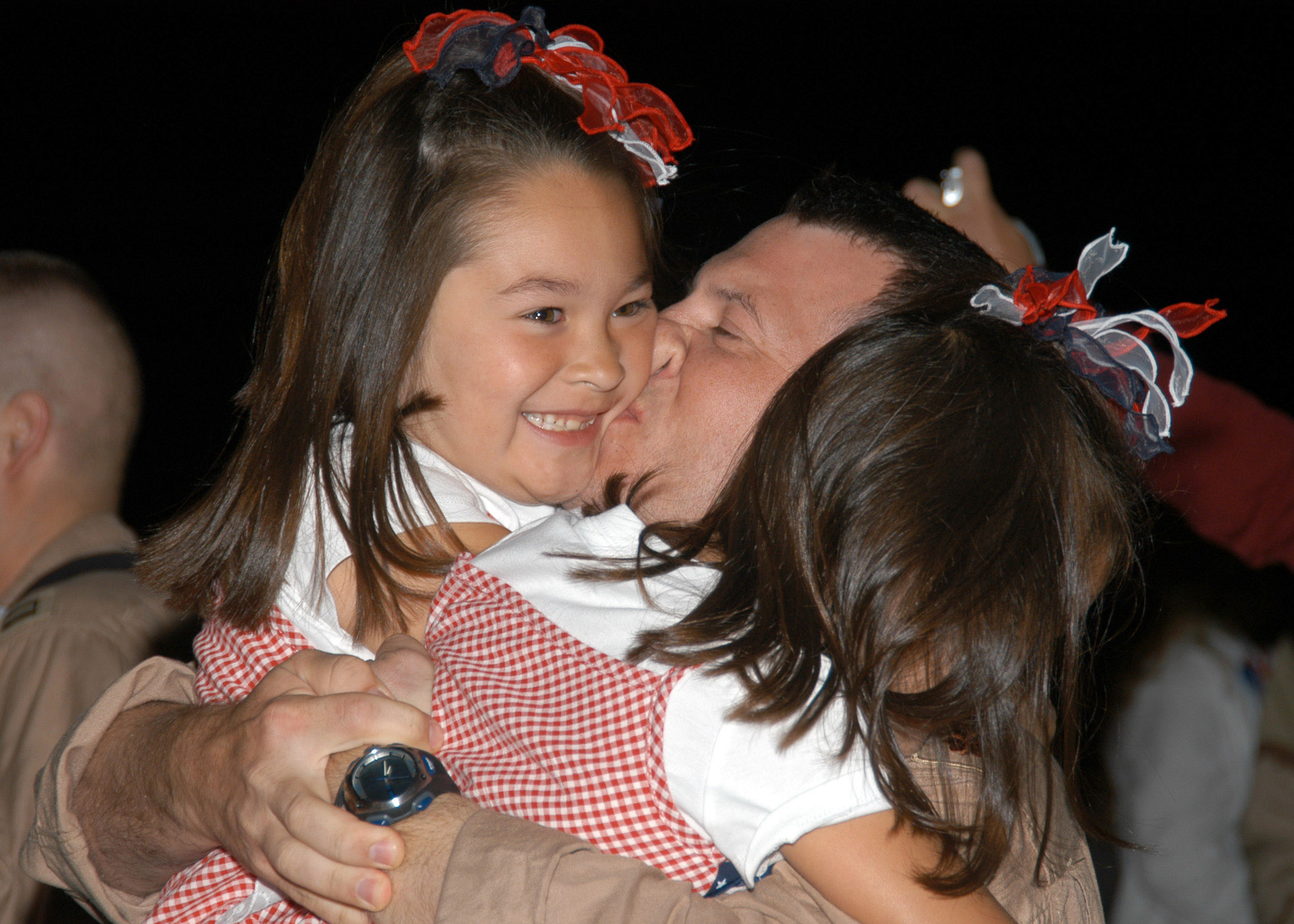 US Navy 070730-N-9860Y-019 Lt. Cmdr. Joe Vandelac, of St. Paul, Minn., kisses his daughters as the Electronic Attack Squadron (VAQ) 134 is welcomed back to Naval Air Station (NAS) Whidbey Island