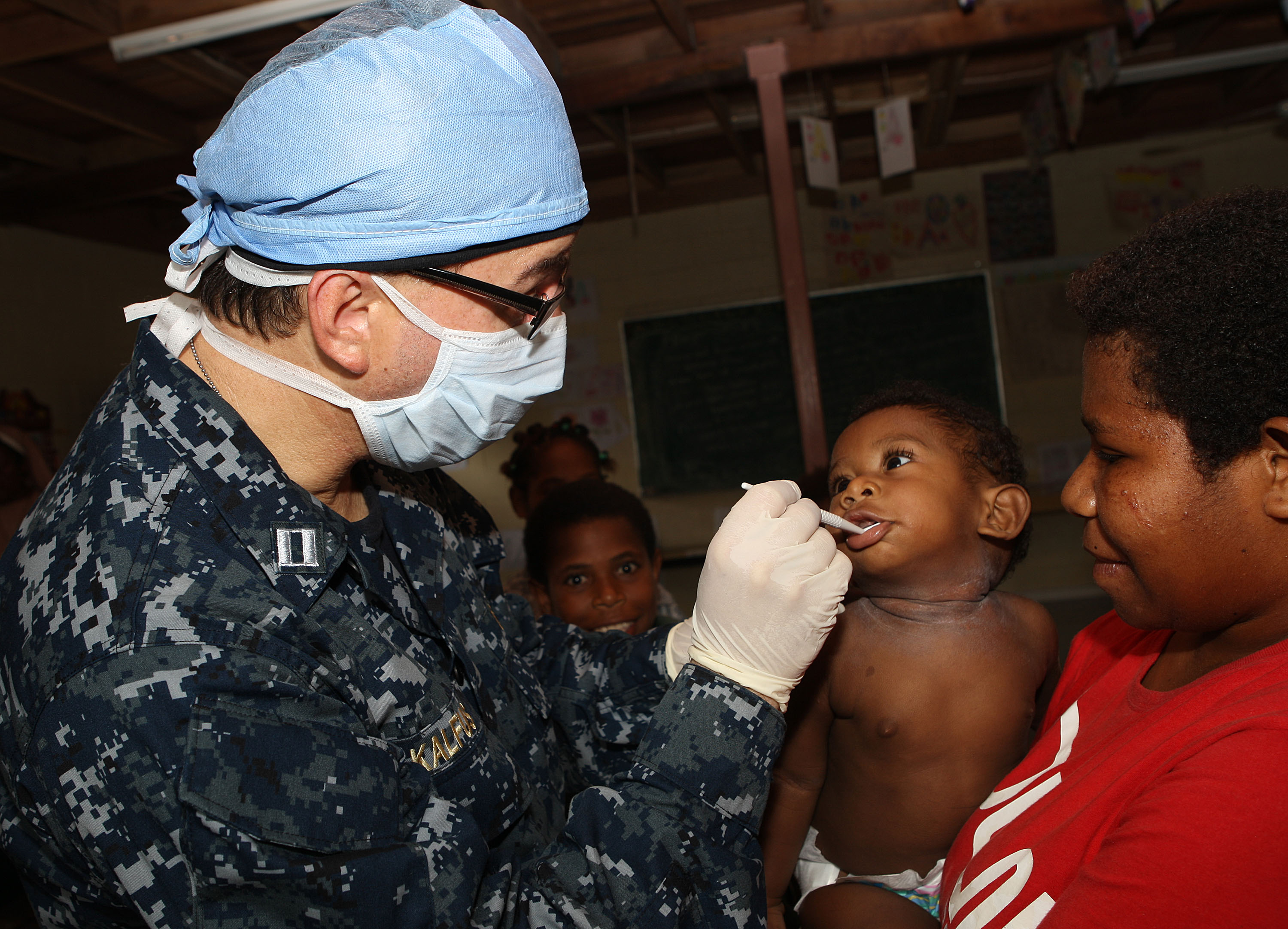 US Navy 110521-O-YY999-003 Lt. Arthur Kalfus, a dentist embarked aboard the amphibious transport dock ship USS Cleveland (LPD 7), checks a baby's t