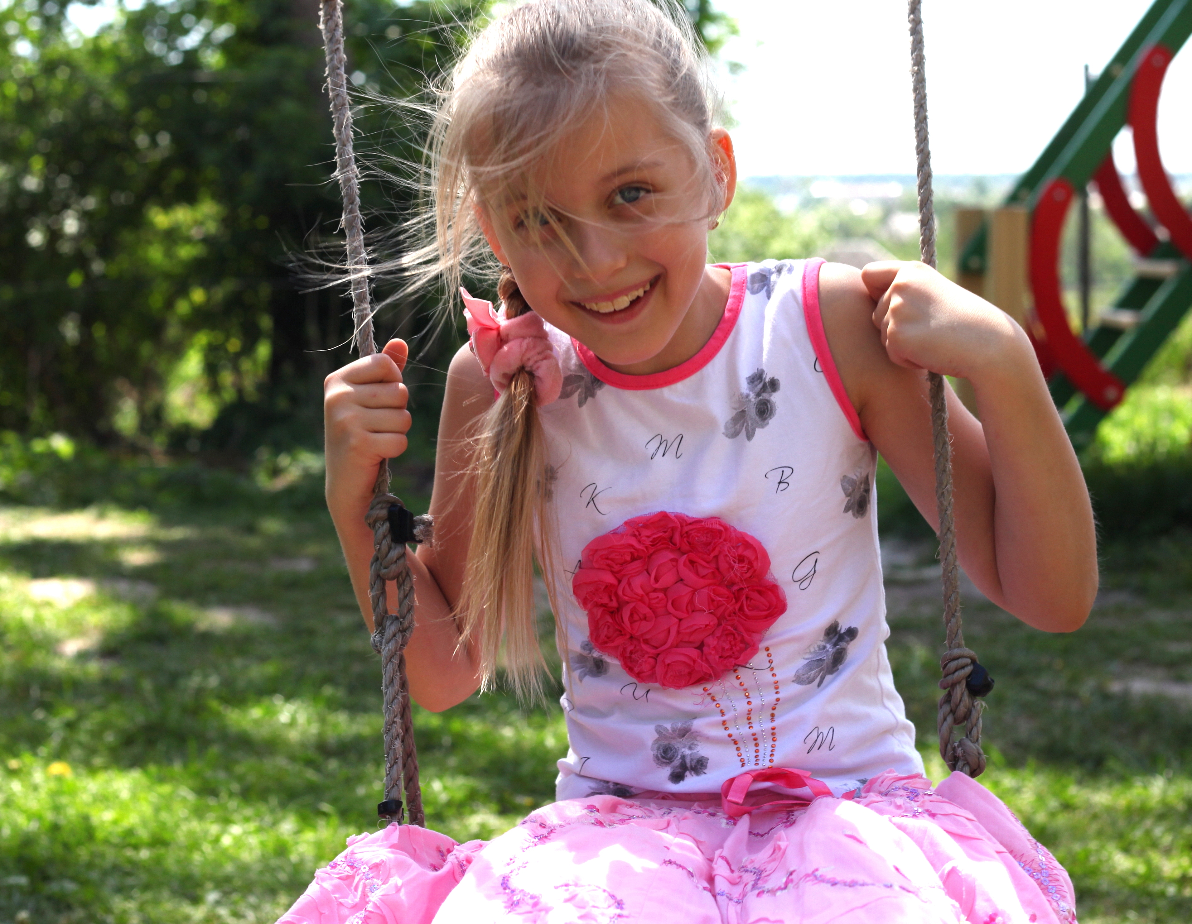 a cute happy young blond Catholic girl on a swing photographed in May 2013, picture 2