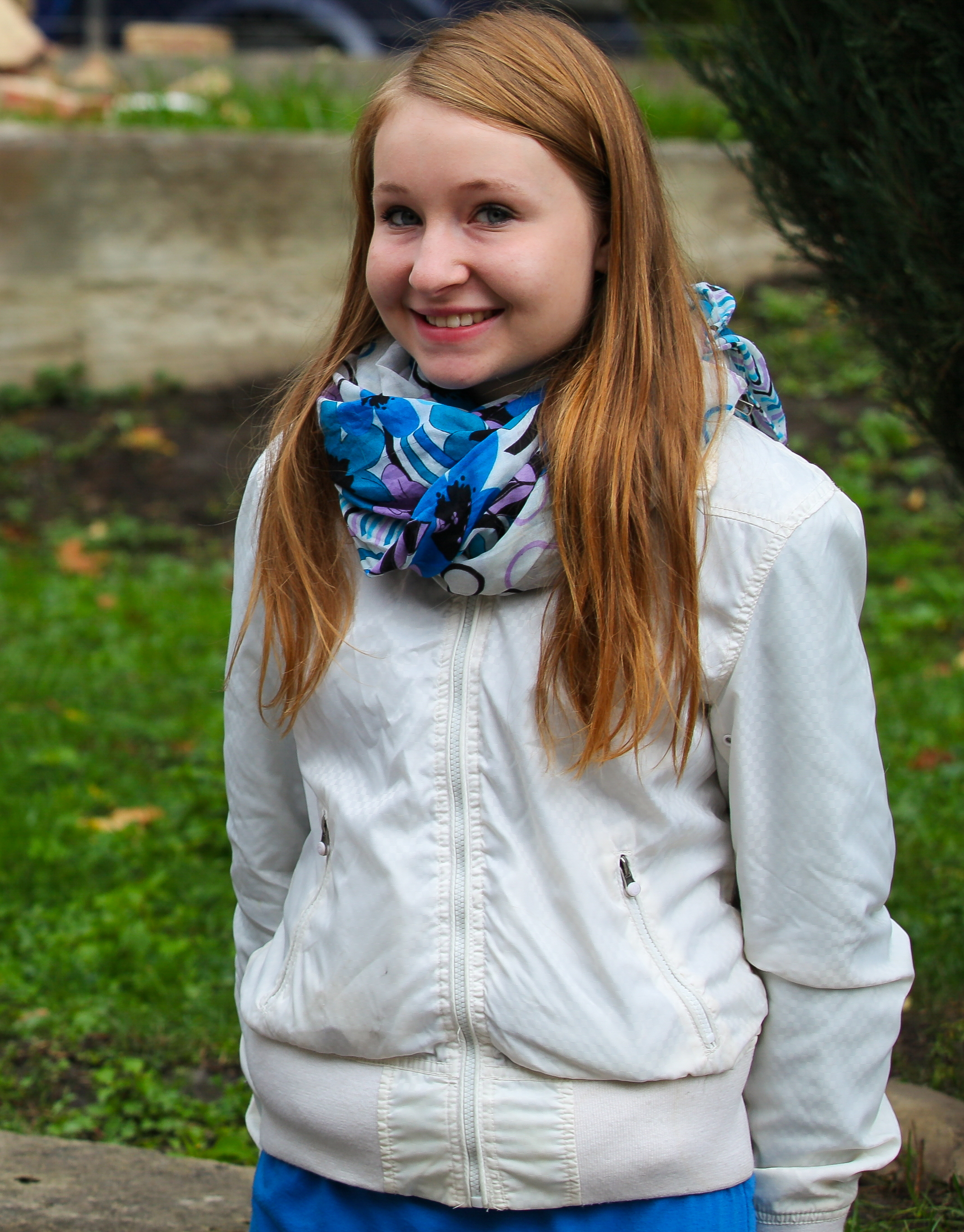 a smiling cute blond girl near a Catholic church photographed in September 2013, picture 1/6