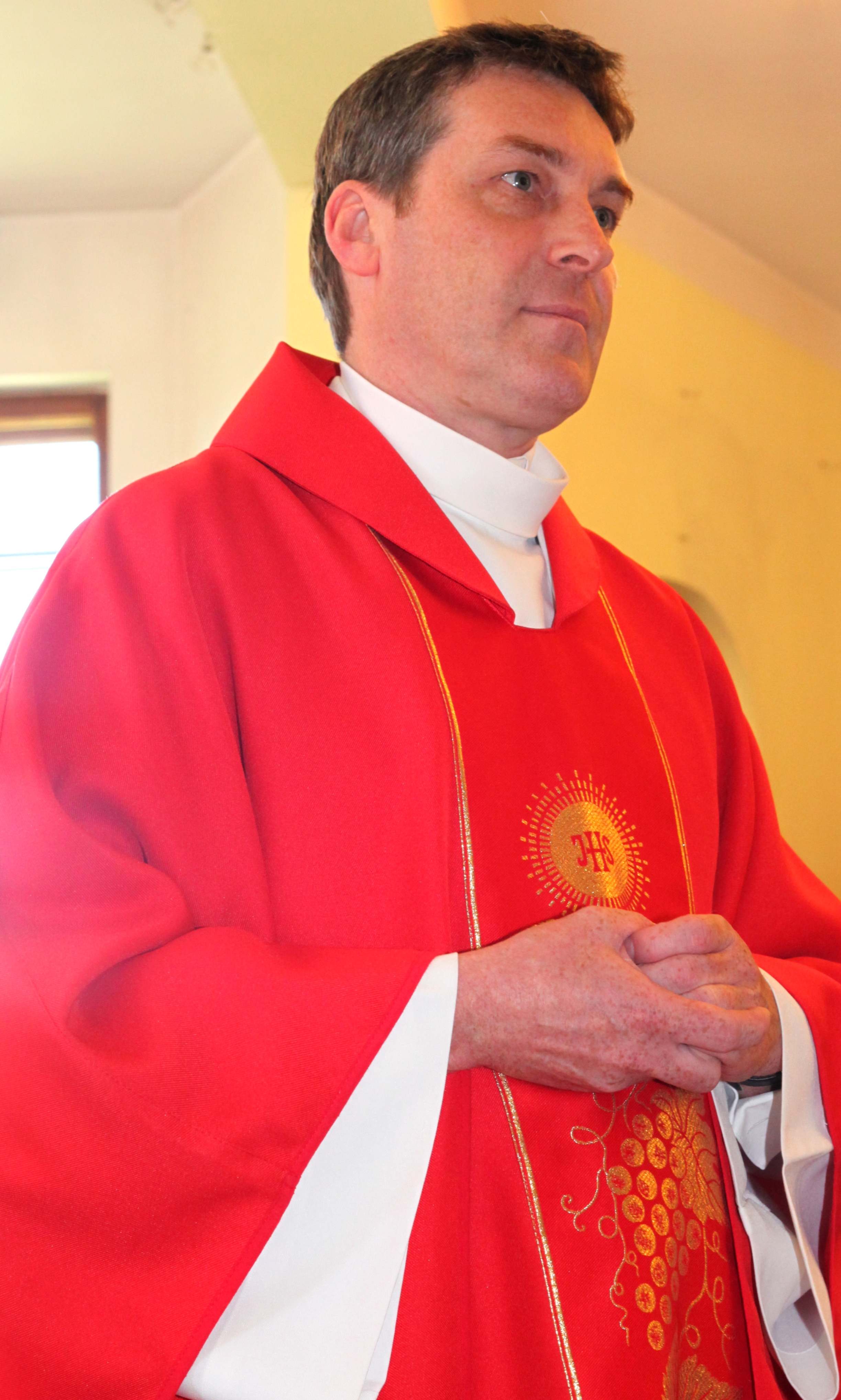 a Catholic priest in red in a church in May 2013, portrait 1