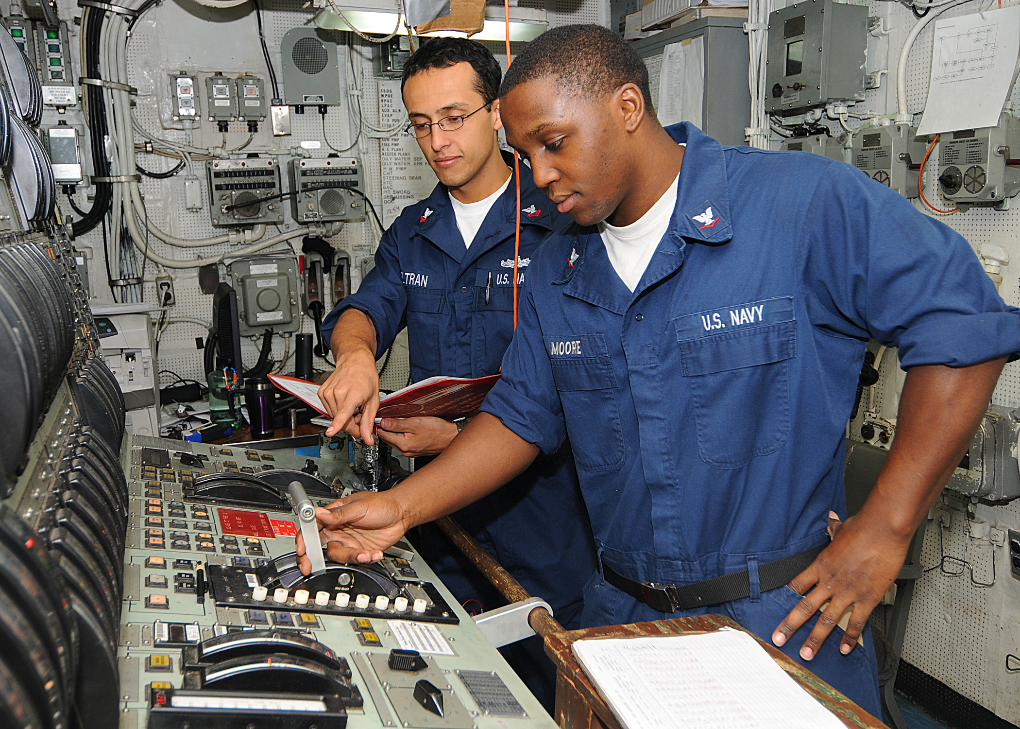 Defense.gov News Photo 100503-N-1082Z-022 - U.S. Navy Petty Officer 2nd Class Alberto Beltran-Lopez provides training on the main propulsion console to Petty Officer 3rd Class Marcus J. Moore