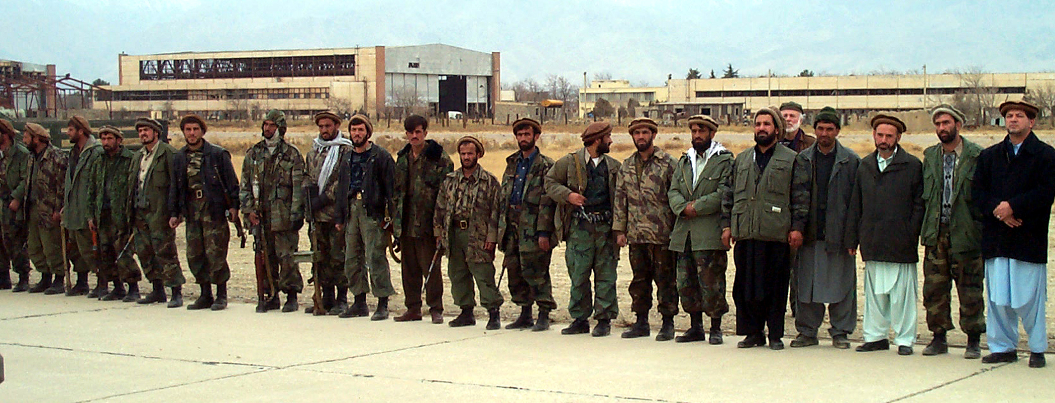 Northern Alliance troops line a runway at Bagram Airbase