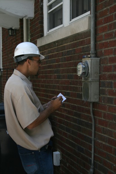 2008-08-12 Technician reading electricity meter at a residence