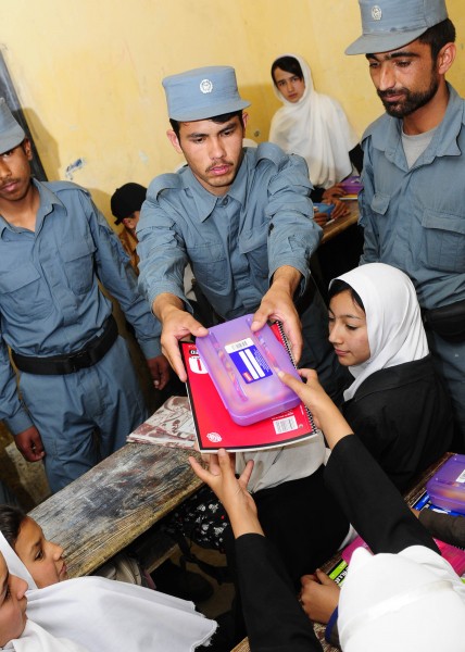 Afghan National Civil Order Police patrolmen hand out school supplies to students in a Kabul classroom. (4678254506)