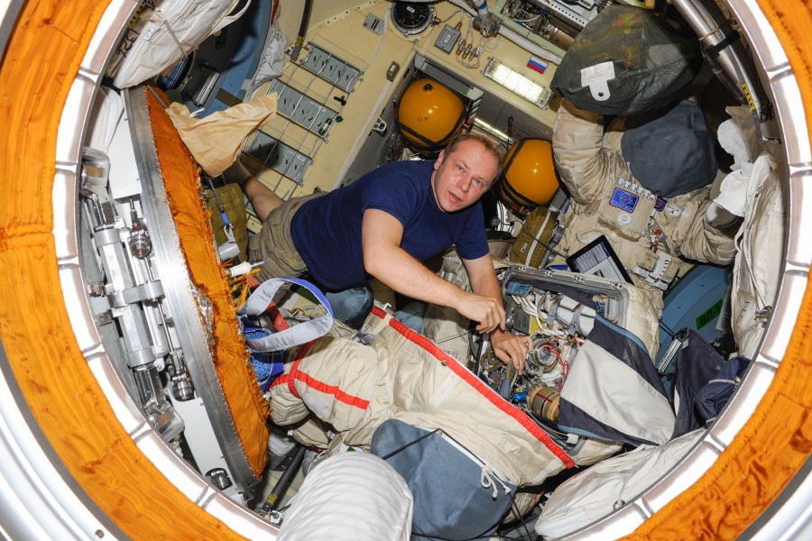 ISS-37 Oleg Kotov works with a Russian Orlan spacesuit in the Pirs module