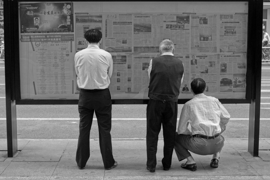 People are reading newspaper on the street