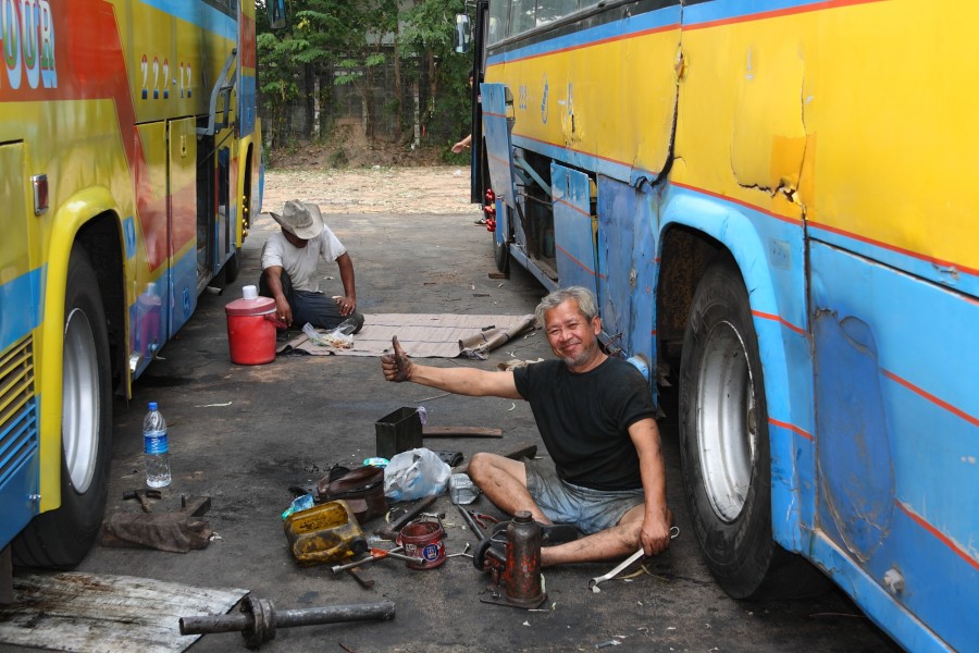 Servicemen repairing buses in Ubon