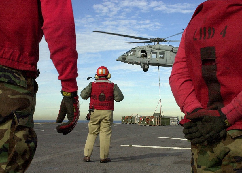 US Navy 040106-N-8977L-011 Aviation Ordnancemen wait to retrieve crates of ammunition on the flight deck